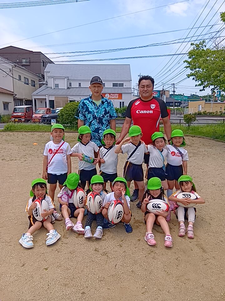 大分市のプリスクール・パシフィックイングリッシュインターナショナルスクール大在校でラグビー体験に参加した園児たちと大分ラグビーフットボール協会の吉田さん